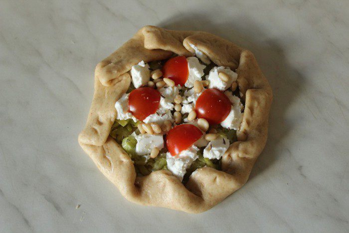 Мини-галеты из цельнозерновой муки с луком-пореем, козьим сыром и кедровыми орехами