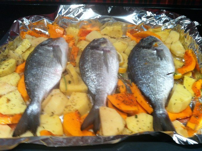 Дорада, запеченная с овощами и травами