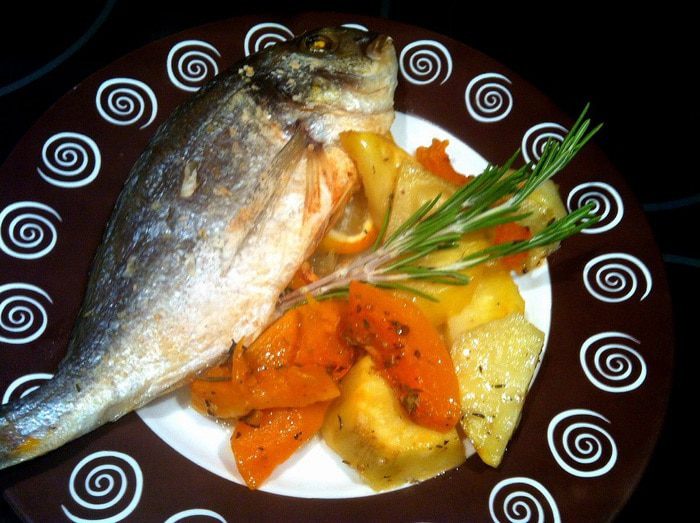 Дорада, запеченная с овощами и травами